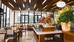 Un restaurant avec un plafond en lambris de bois, de grandes fenêtres et un buffet.