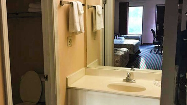 A bathroom with a sink, mirror, and towel rack. - Magnuson Hotel Marietta (Marietta)