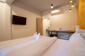 A hotel room with a bed, a TV mounted on the wall, a small kitchenette, and a bathroom with a mirror and towel rack. - Lazy Sandals Koh Samed (Rayong)
