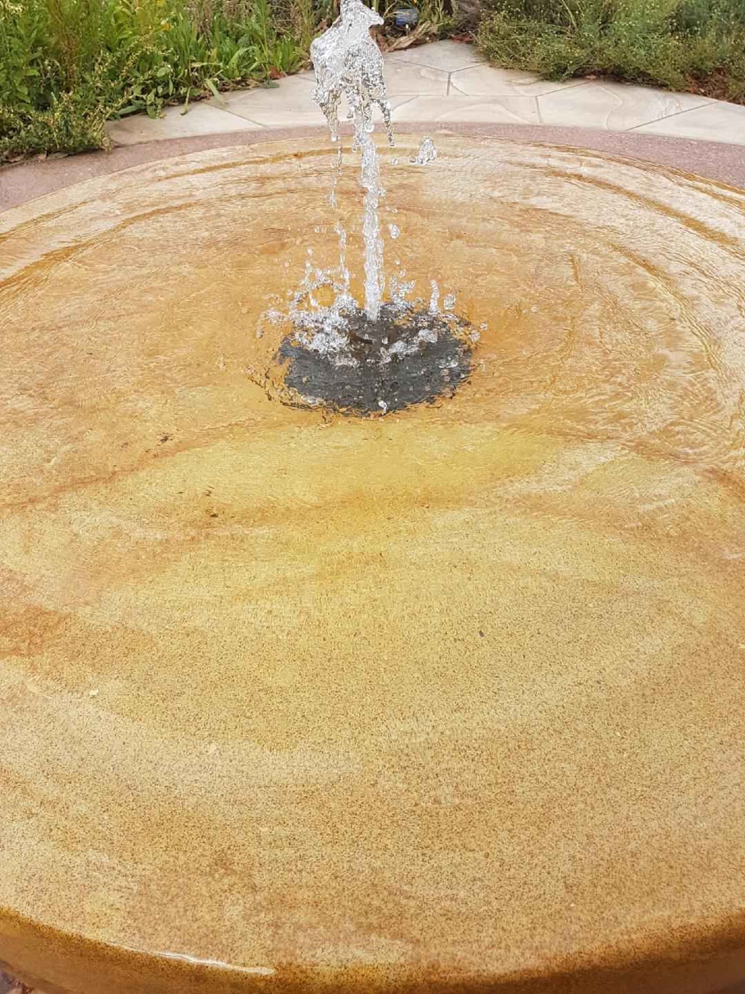A circular water fountain with a central spout.