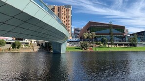 A modern building with a curved glass facade and a water body in front. - Adelaide Style Accommodation near City (North Adelaide)