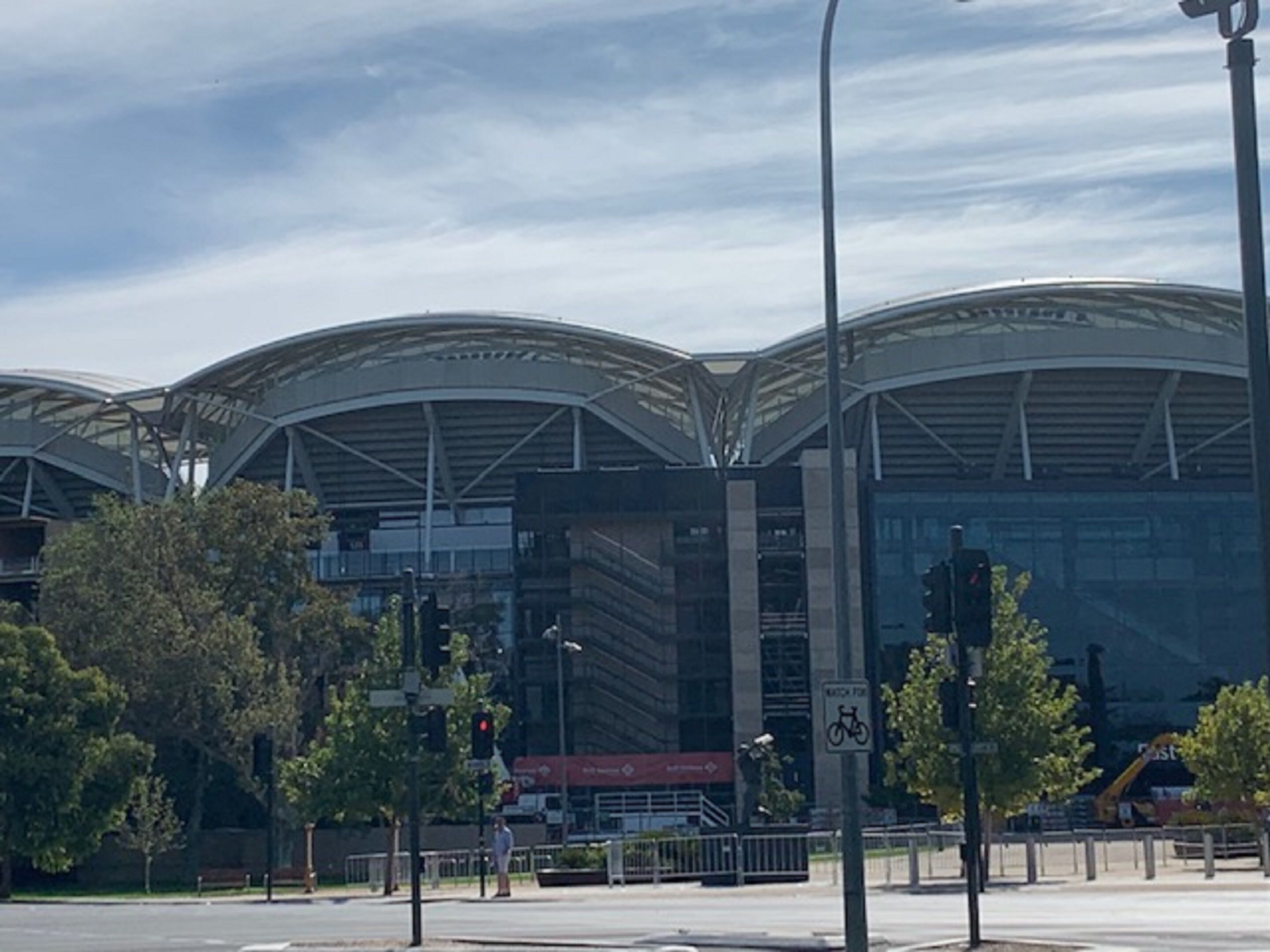 A modern building with a curved roof and a pedestrian walkway.