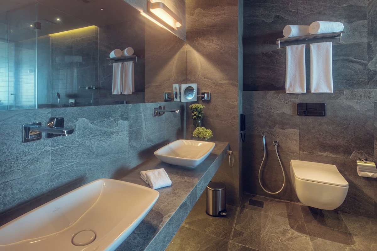 Ein modernes Badezimmer mit zwei Waschbecken, einer Toilette und einer Dusche.