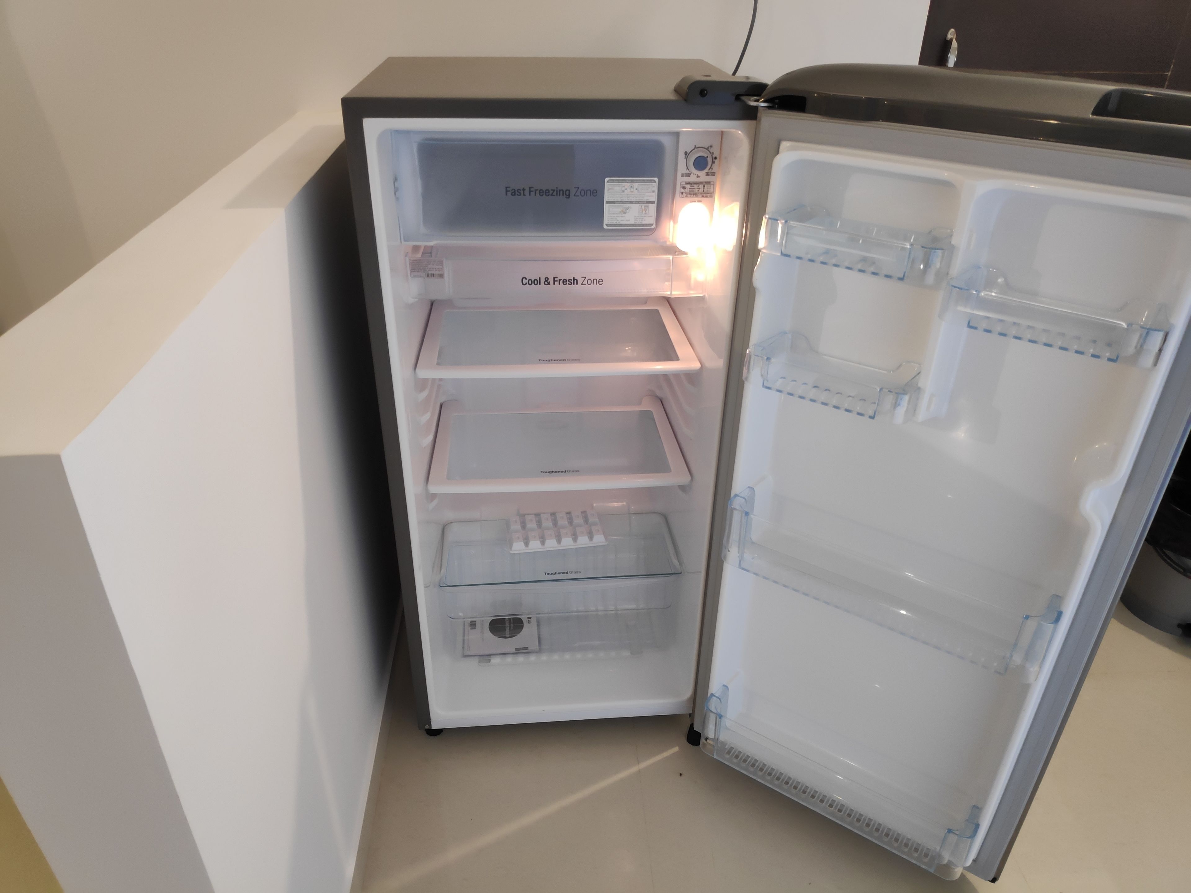 An open refrigerator with labeled compartments for 'Fast Freezing Zone' and 'Cool & Fresh Zone'.