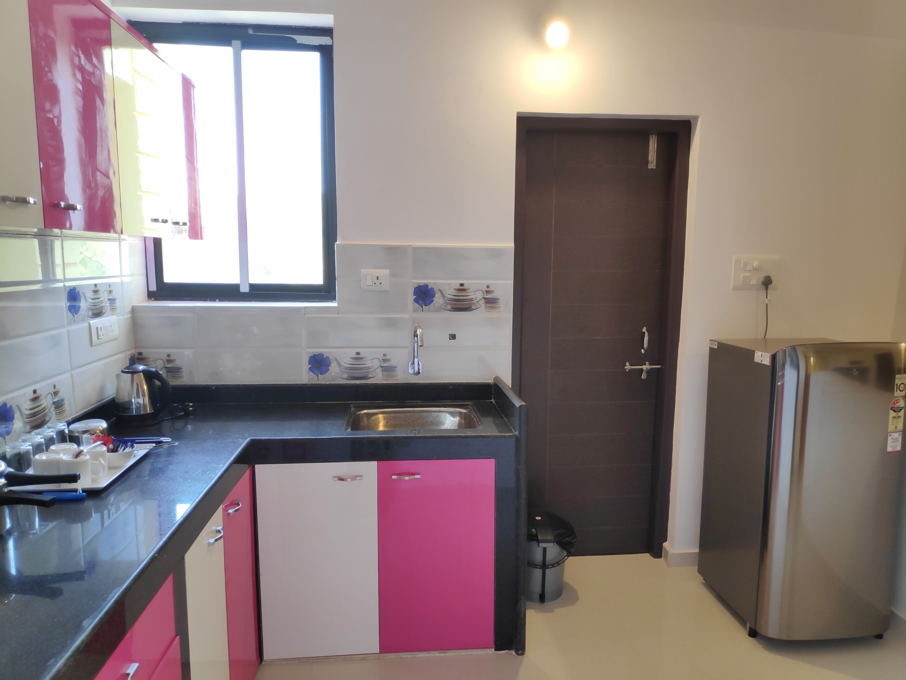 A kitchen with a sink, a refrigerator, and a window.