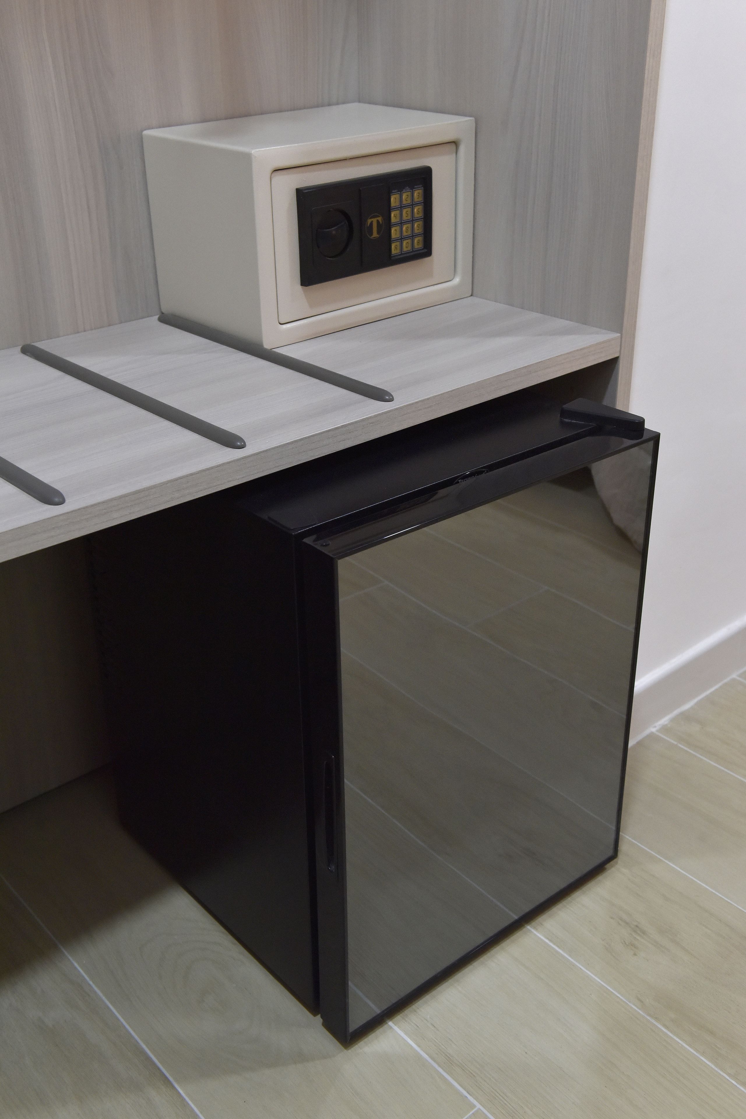 A compact kitchen with a built-in microwave and a black refrigerator.