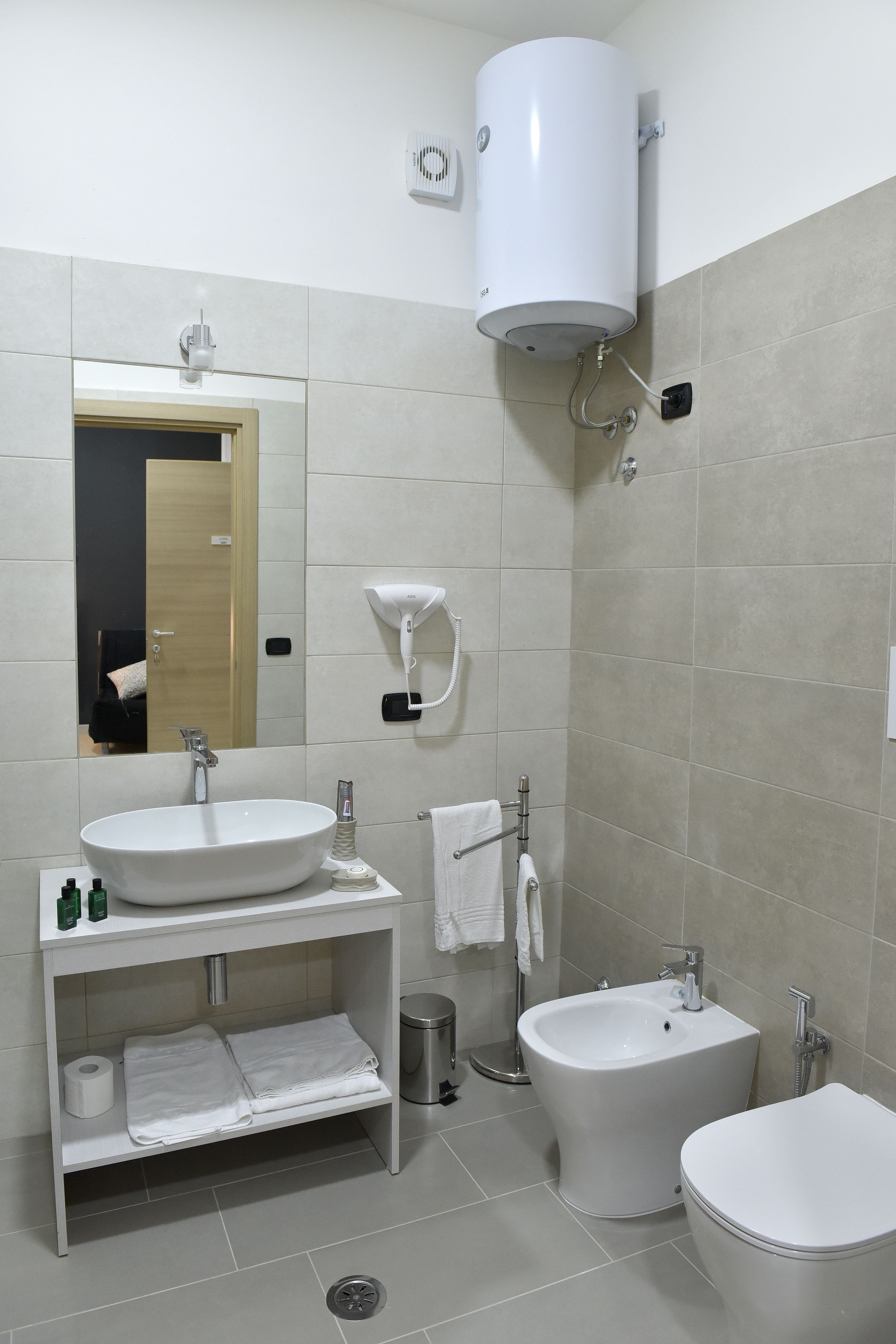 Une salle de bain moderne avec un lavabo, un bidet et des toilettes.