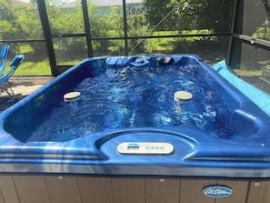 Relax in the hot tub surrounded by lush greenery.