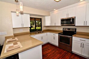 Enjoy cooking in this well-equipped kitchen with a large island, double oven, microwave, and sink.