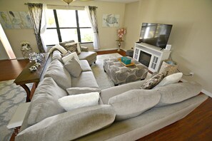 Relax in style with a comfortable sectional sofa and fireplace, perfect for unwinding in this inviting living space.