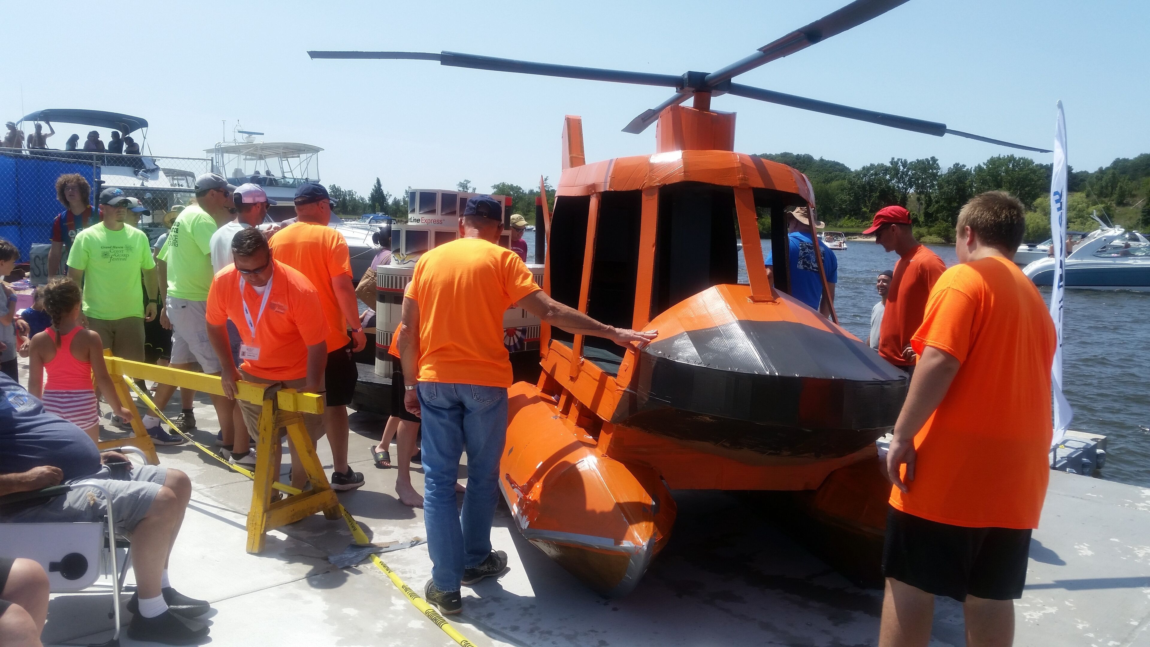 Un grupo de personas en un bote con un helicóptero naranja.