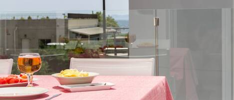 A table set with a pink tablecloth, a glass of drink, and plates of food.