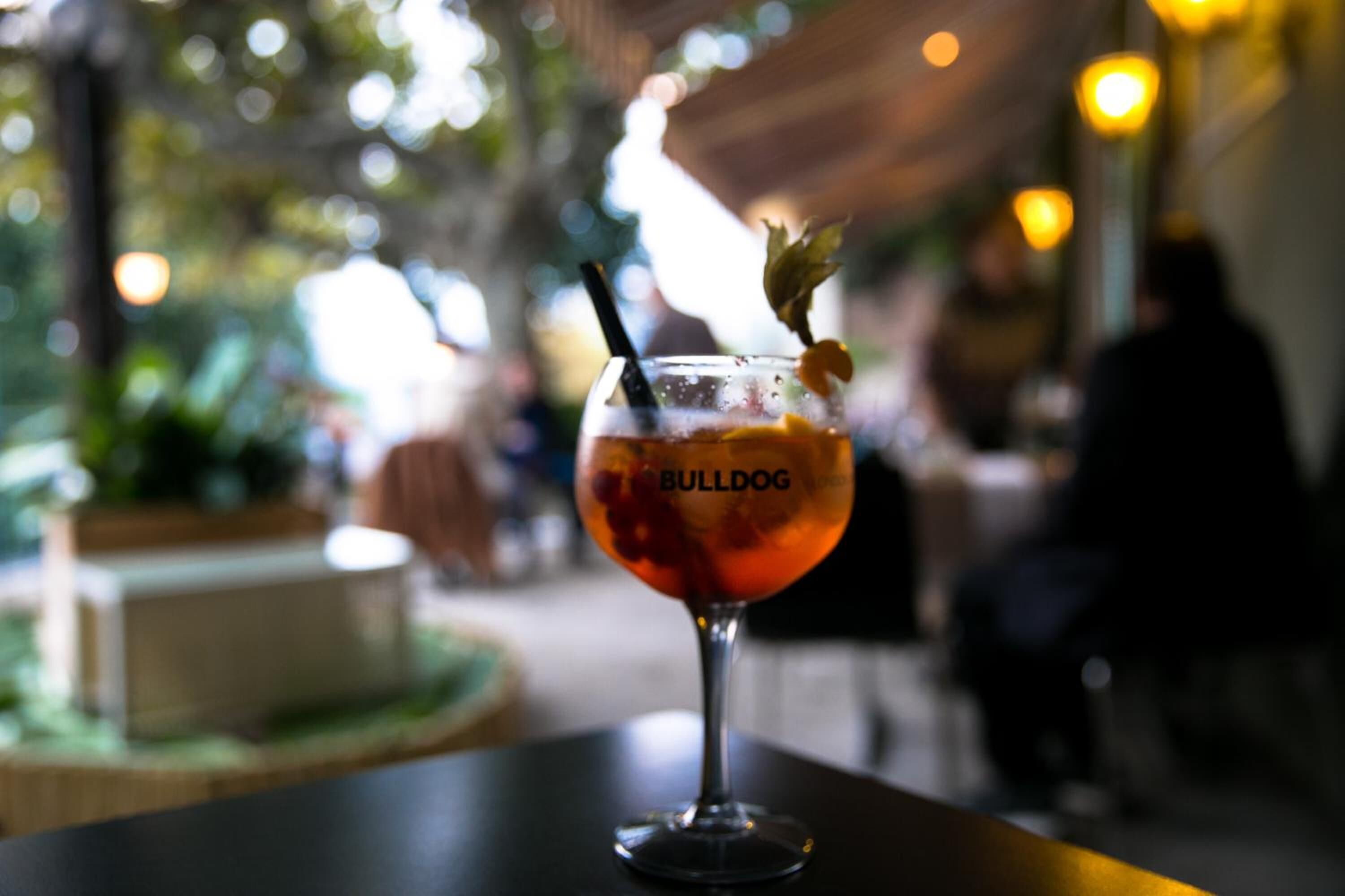 Ett glas med dryck, en sugrör och en dekoration på ett bord i en restaurang.