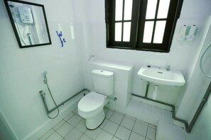 A small, clean bathroom with a toilet, sink, and shower. - Hommie 1934 (George Town)