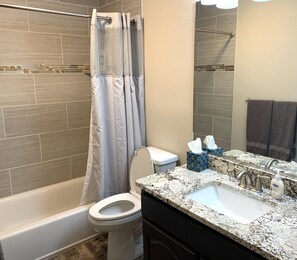 Downstairs bathroom with beautiful granite and tile.