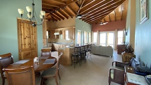Eine geräumige Küche mit Holzausstattung, ein Essbereich mit Tisch und Stühlen sowie ein Wohnzimmer mit Sofa und Couchtisch.