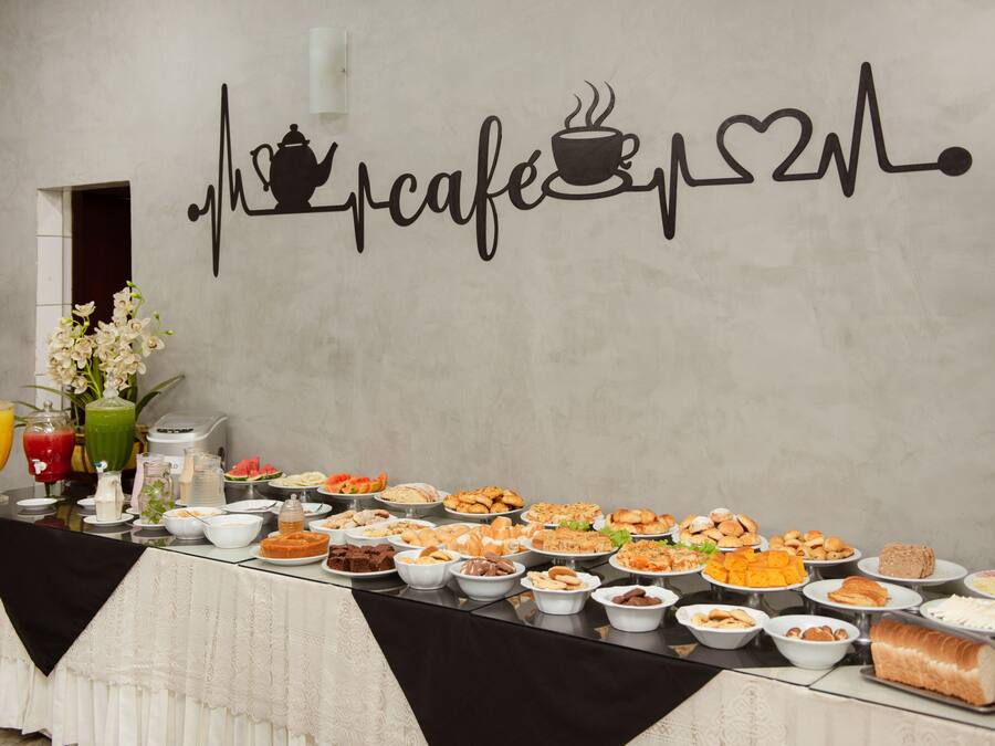 Una mesa de buffet con diferentes alimentos y una pared decorada con motivos de cafetería.
