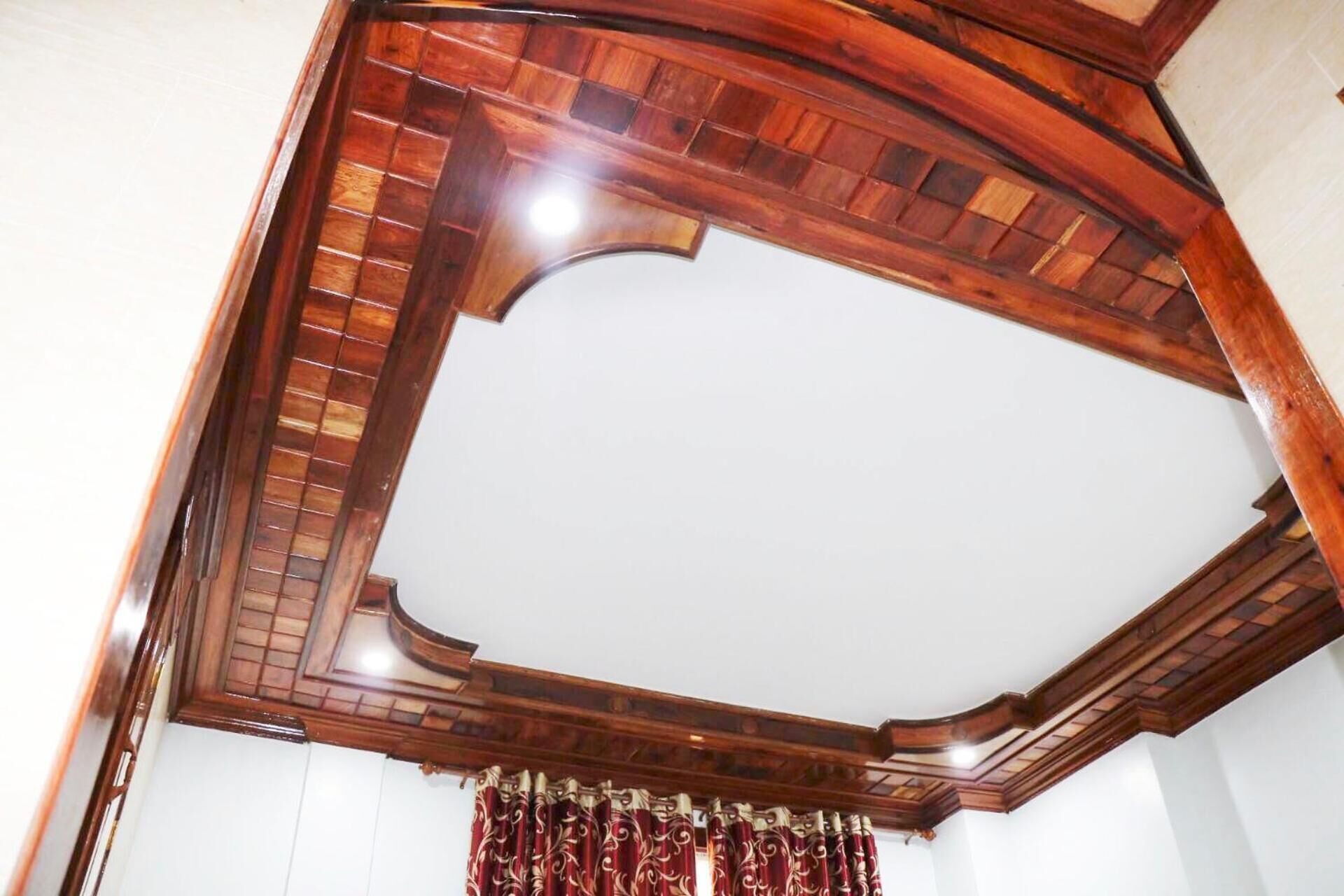 A corner of a room with a wooden ceiling and a white wall.