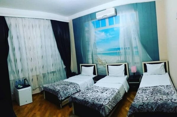 Habitació triple estàndard | Caixa forta a l'habitació, habitacions insonoritzades i roba de llit 