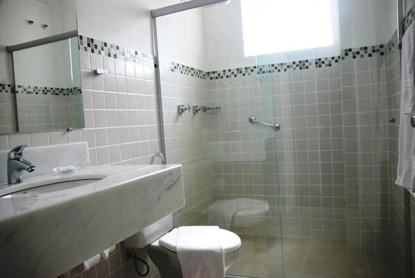Un baño con ducha, inodoro y lavabo.