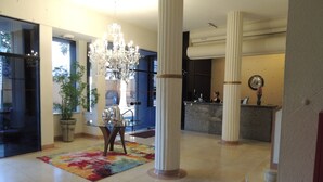 A spacious lobby with a chandelier, a reception desk, and a colorful rug. - Grande Hotel Amparo (Amparo)