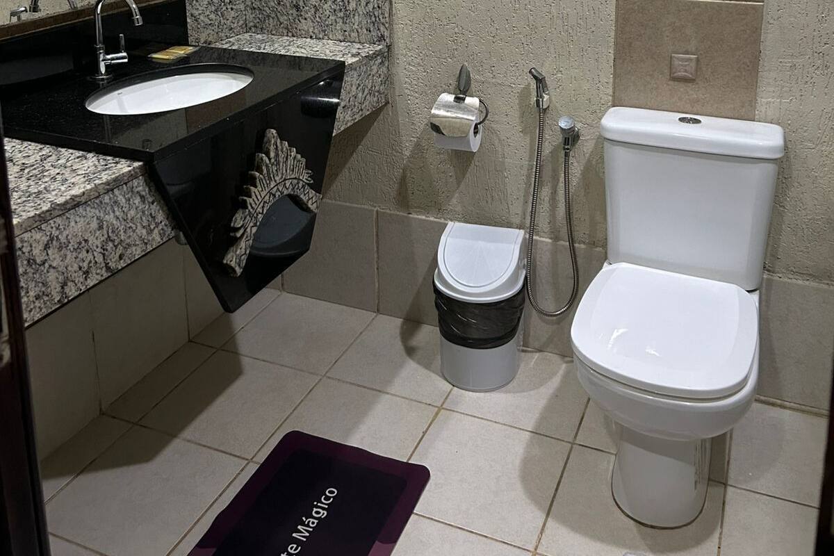 A bathroom with a sink, mirror, toilet, and shower.