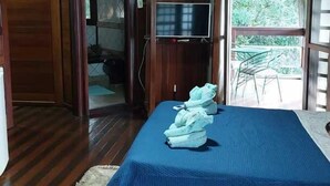 Ein Zimmer mit Bett, Fernseher und Blick auf Grün.