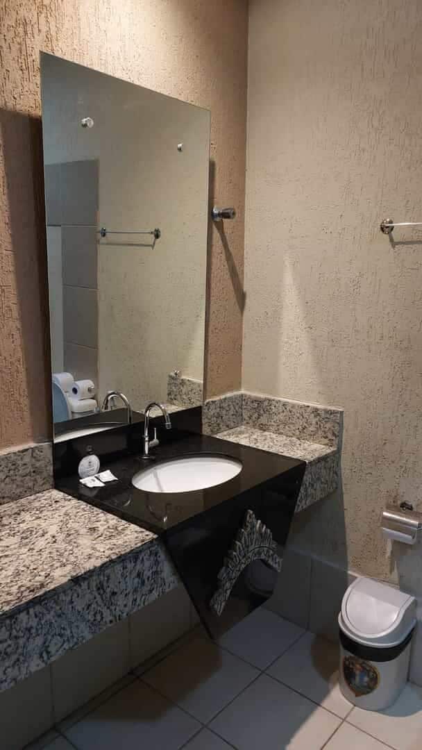 Een badkamer met een wastafel, spiegel en toilet.