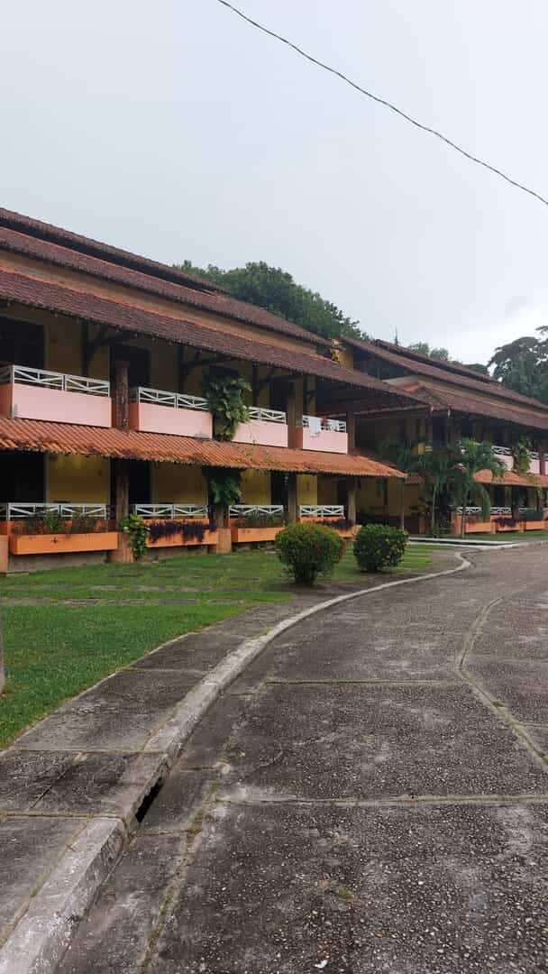 Uma fileira de edifícios de dois andares com sacadas, um caminho de paralelepípedos e um gramado bem cuidado.