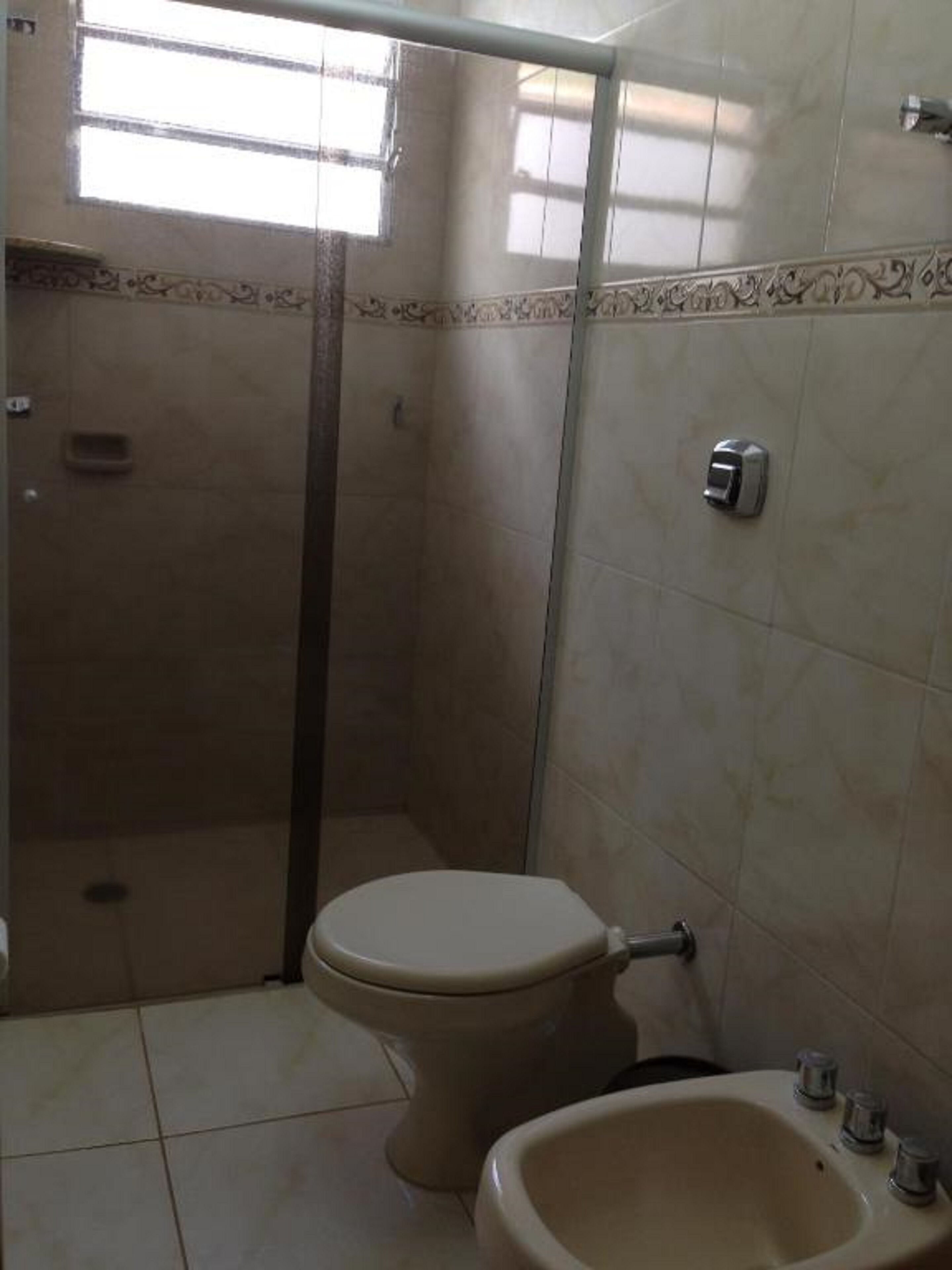 A bathroom with a toilet, a sink, and a shower stall.