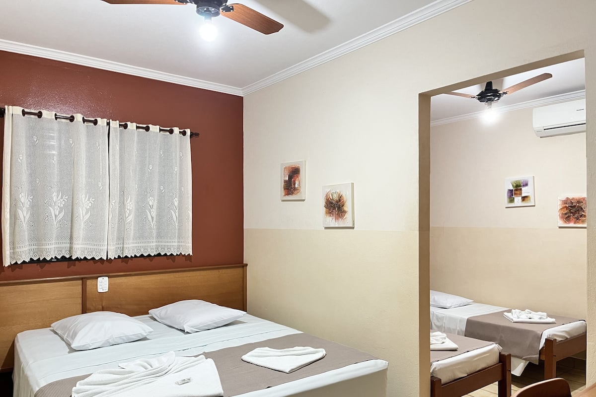 Une chambre d’hôtel avec un lit, un bureau et un miroir.