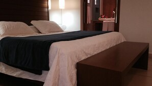 A modern hotel room with a large bed, a bedside table, and a mirror. - Lider Hotel Ituiutaba (Ituiutaba)