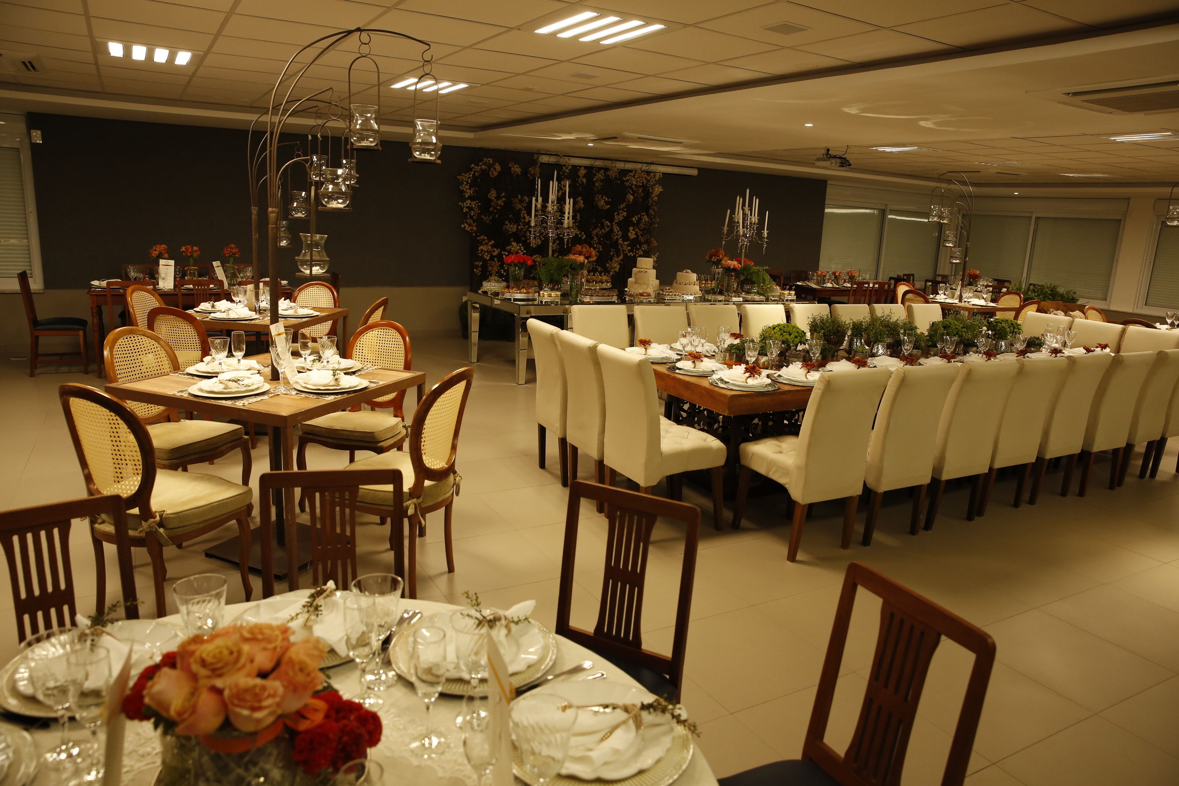 Comedor con varias mesas dispuestas para una comida, con una combinación de sillas de madera y tapizadas.