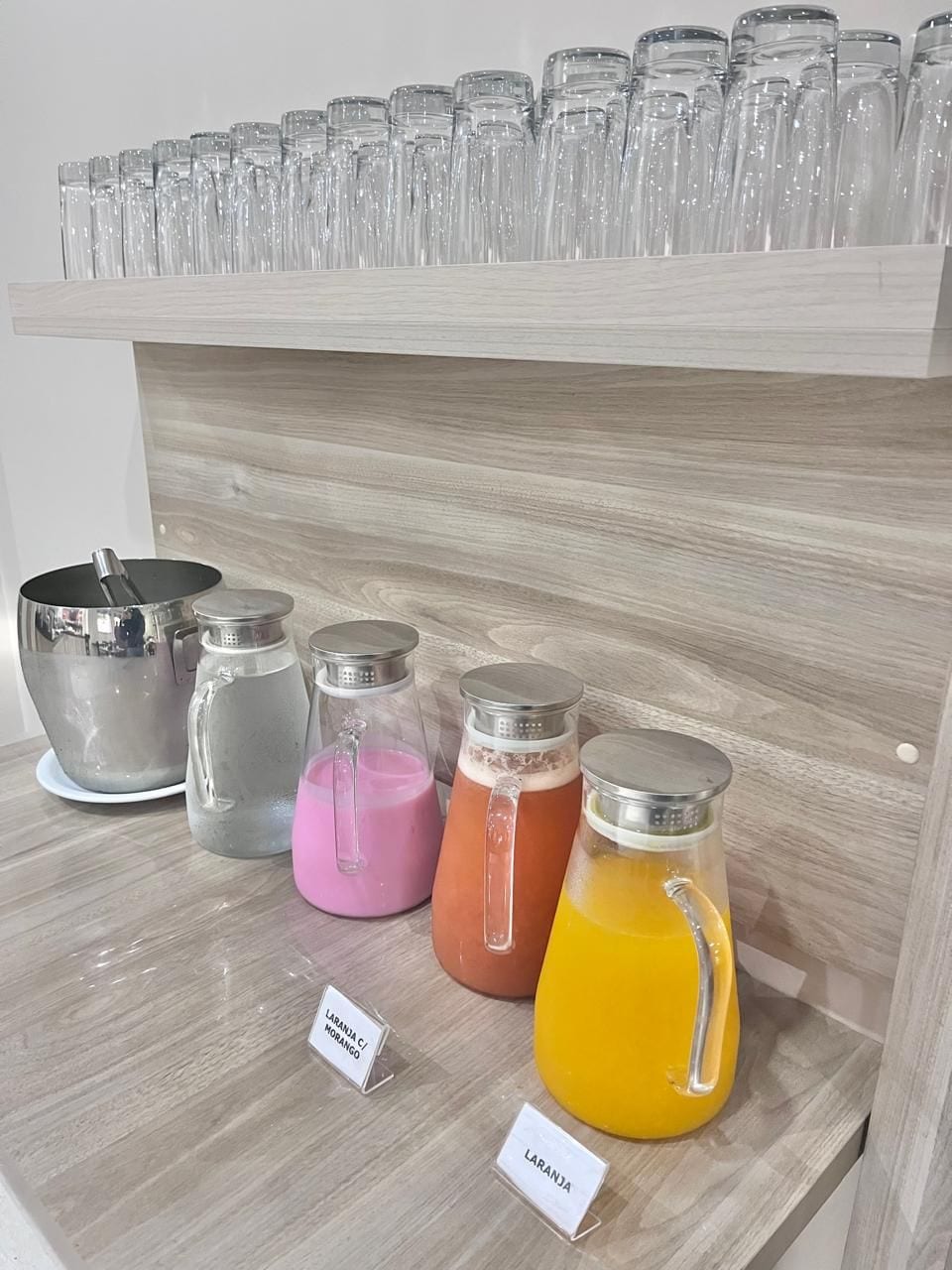 A shelf with various glass containers and a metal pot, likely for beverages.