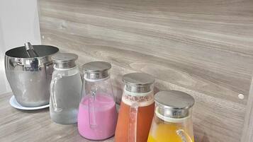 A shelf with various glass containers and a metal pot, likely for beverages.