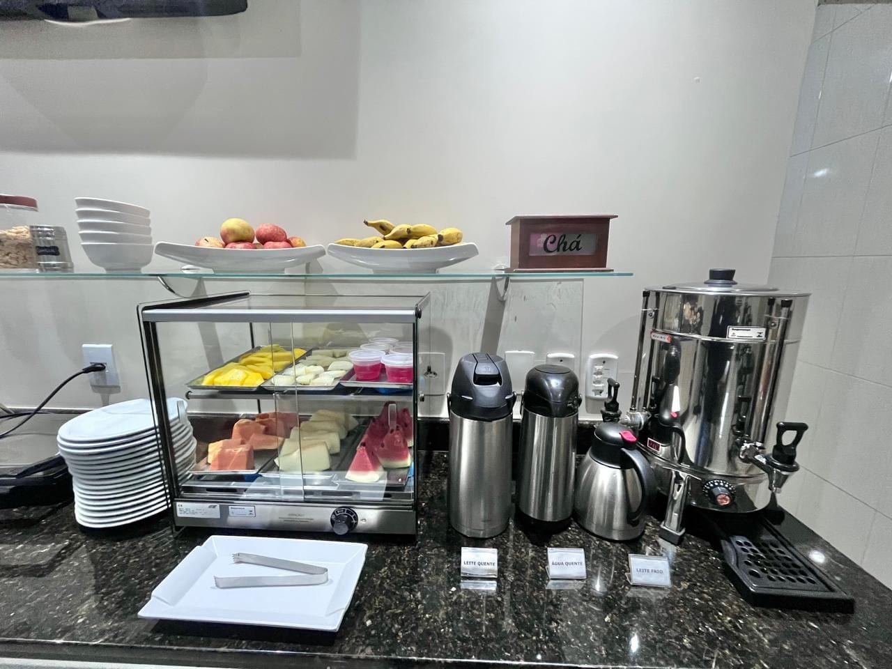 A breakfast buffet with various food items and coffee machines.