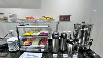 A breakfast buffet with various food items and coffee machines.