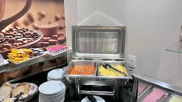 A buffet setup with various food items and utensils.