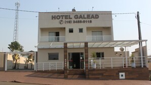 Un edificio de dos pisos con un cartel que dice "HOTEL GALEAD" y un número de teléfono.