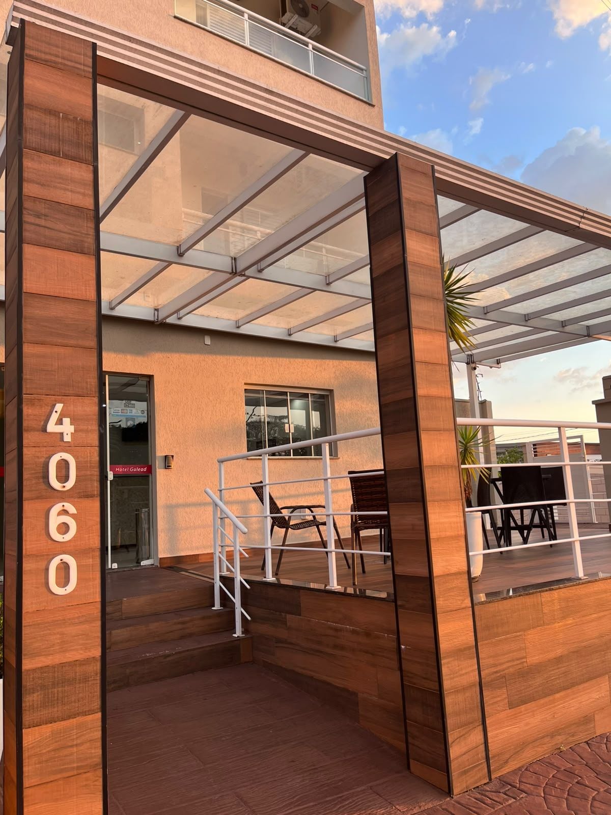 Entrada de hotel con diseño moderno, destacando un frente de vidrio, paneles de madera y un cartel con el número 4060.