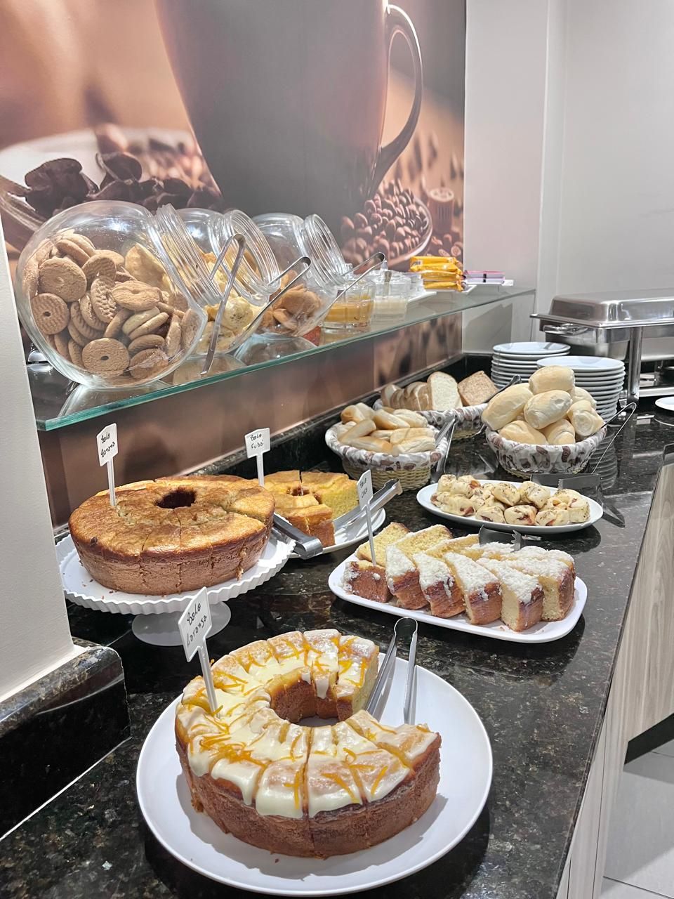 Un bufé con diversas opciones de panadería, incluyendo pasteles, galletas y pan.