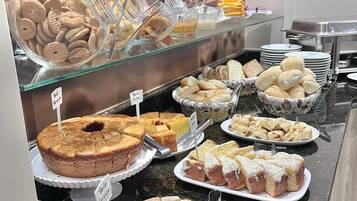Un bufé con diversas opciones de panadería, incluyendo pasteles, galletas y pan.
