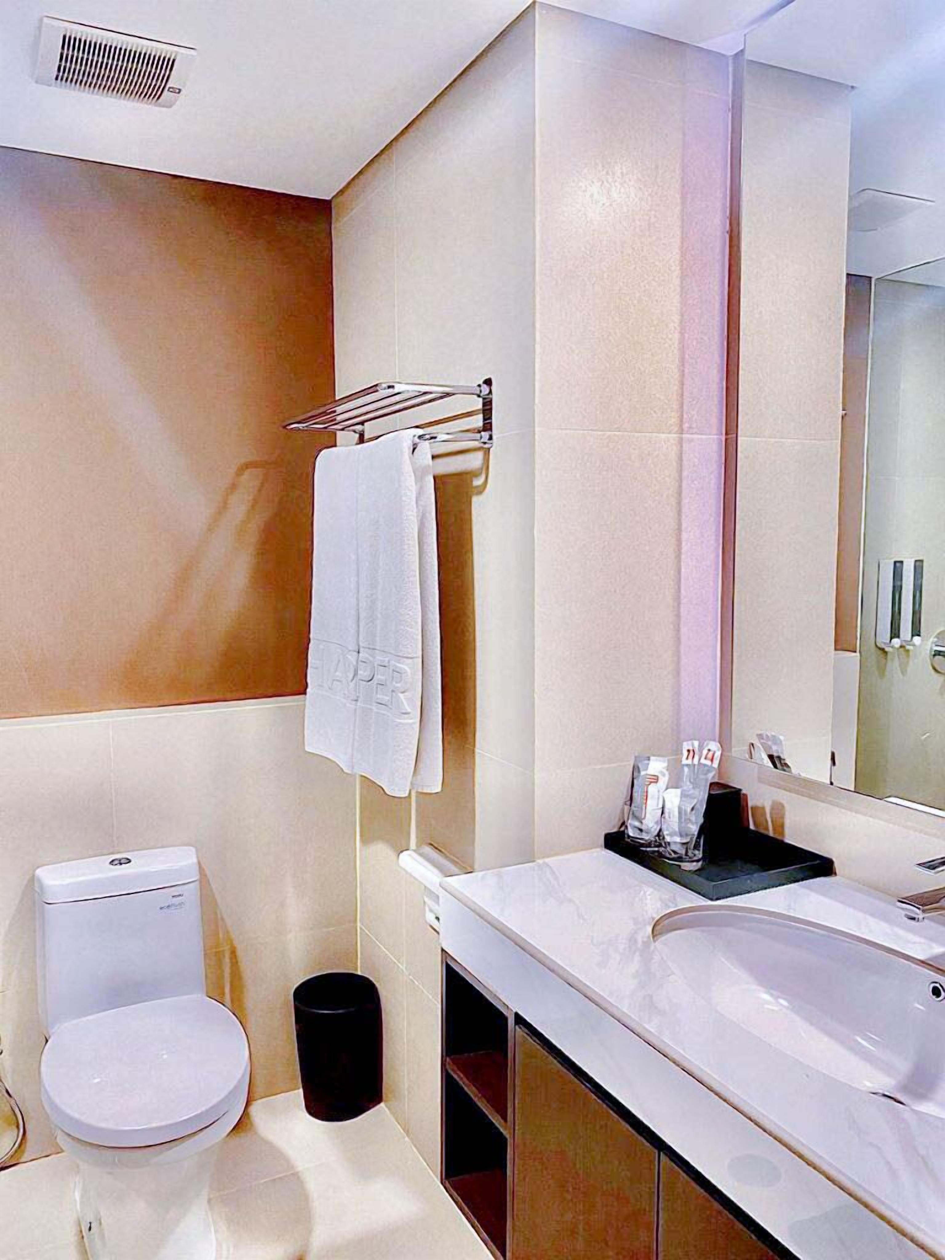 A modern bathroom with a toilet, sink, and mirror.