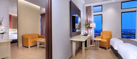 Una habitación de hotel con cama, escritorio, silla y sofá.