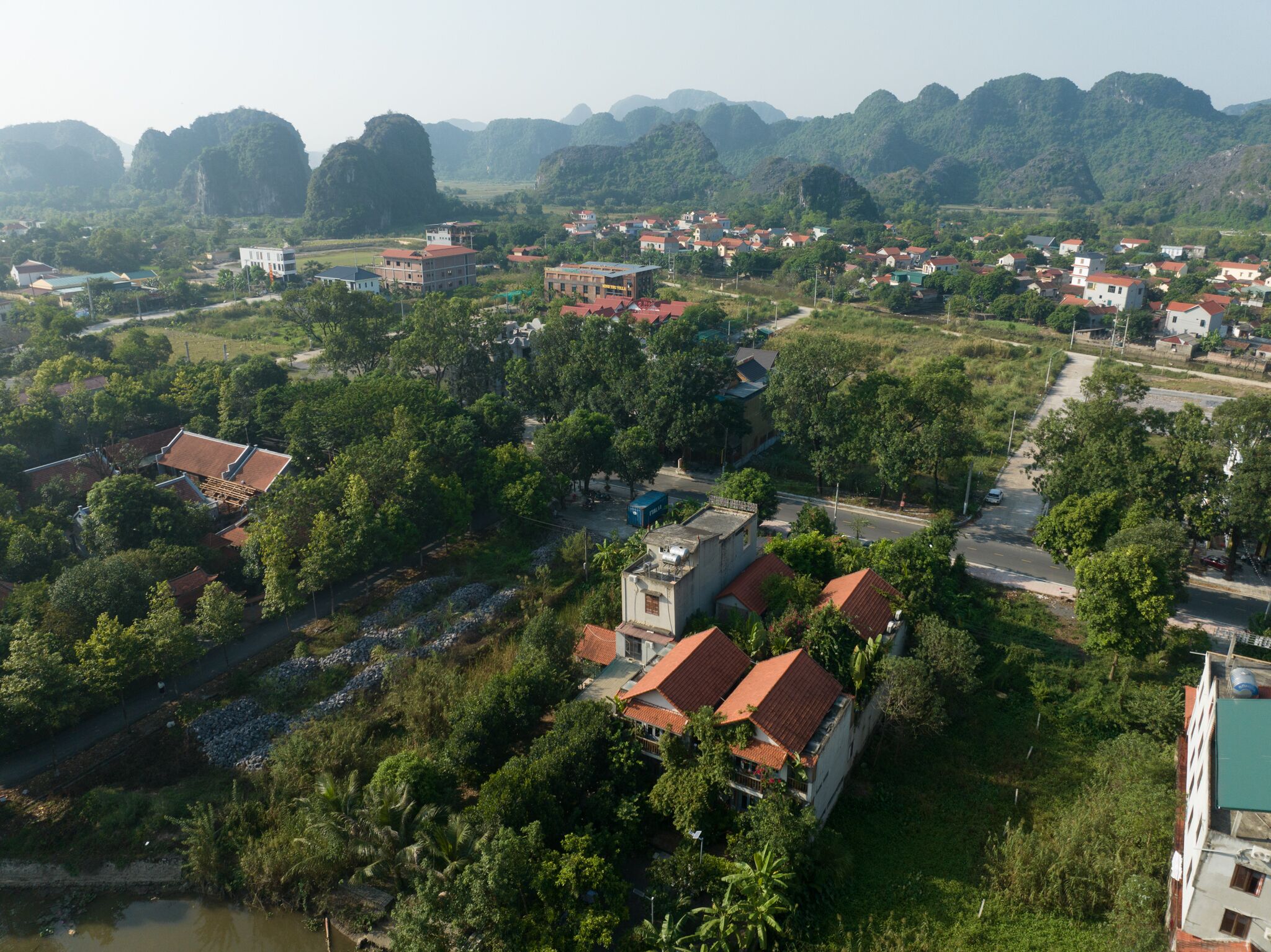 An aerial view of a town with buildings, roads, and surrounding greenery.