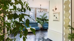 Una sala de estar moderna con un sofá azul, una mesa de centro y una planta en maceta.