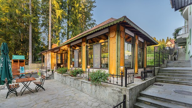 Un edificio de madera con amplios ventanales y un patio de piedra.
