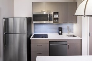 A compact kitchen with a stainless steel refrigerator, a microwave, a coffee maker, and a dishwasher. - Hyatt House Charleston / Mount Pleasant (Mount Pleasant)