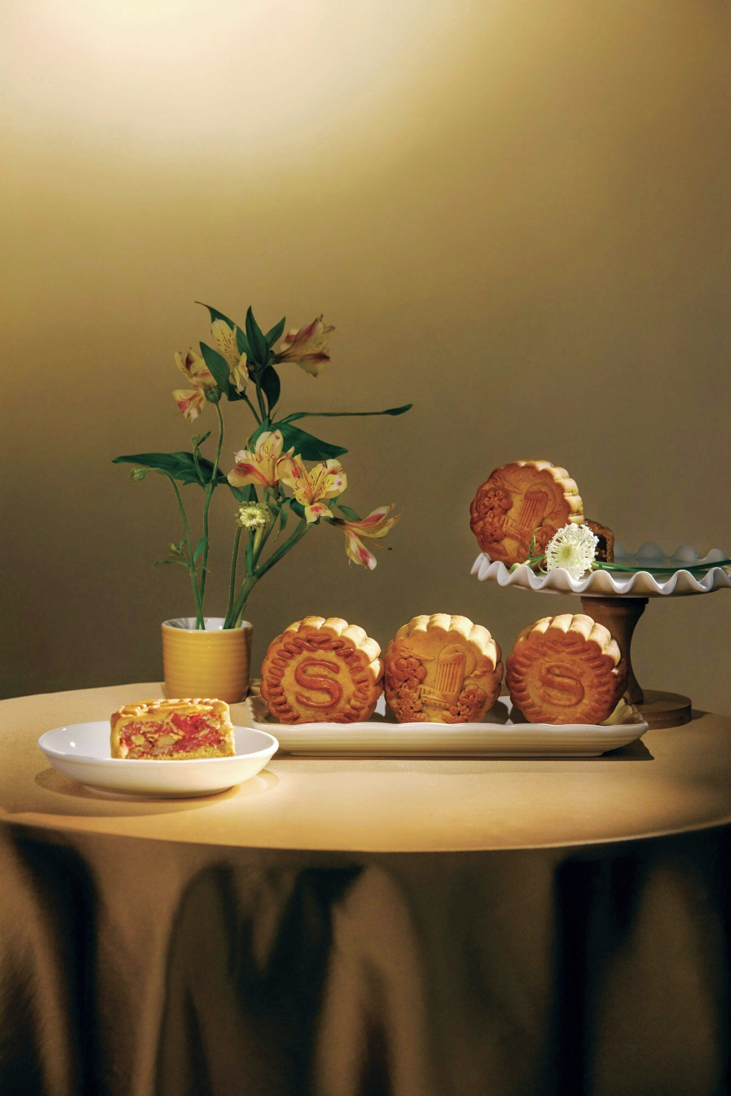A table with pastries and a potted plant.