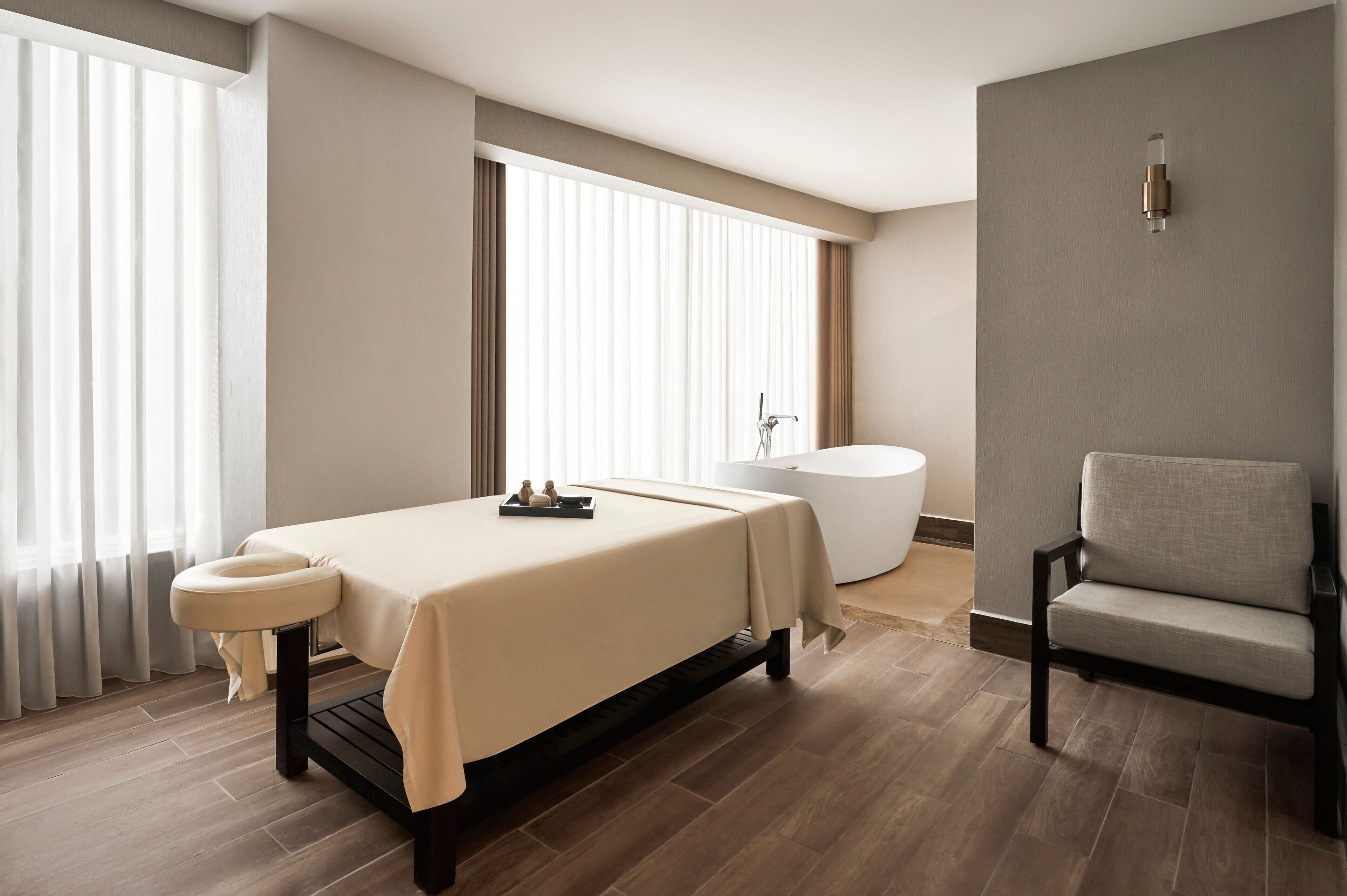 Une chambre d’hôtel moderne équipée d’un lit, d’une baignoire et d’un coin salon.
